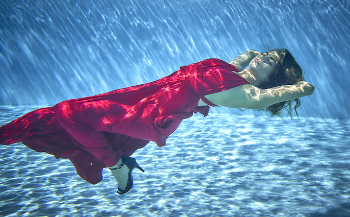 Bianca woman underwater in red dress and high heels