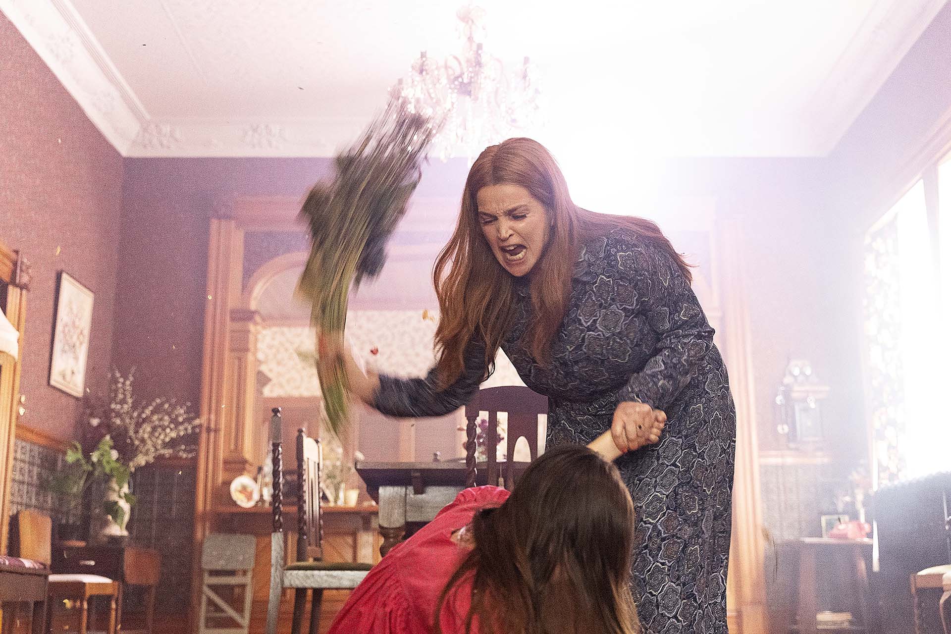 A flashback still of Julia Ormond's character in Reunion whacking a child with flowers