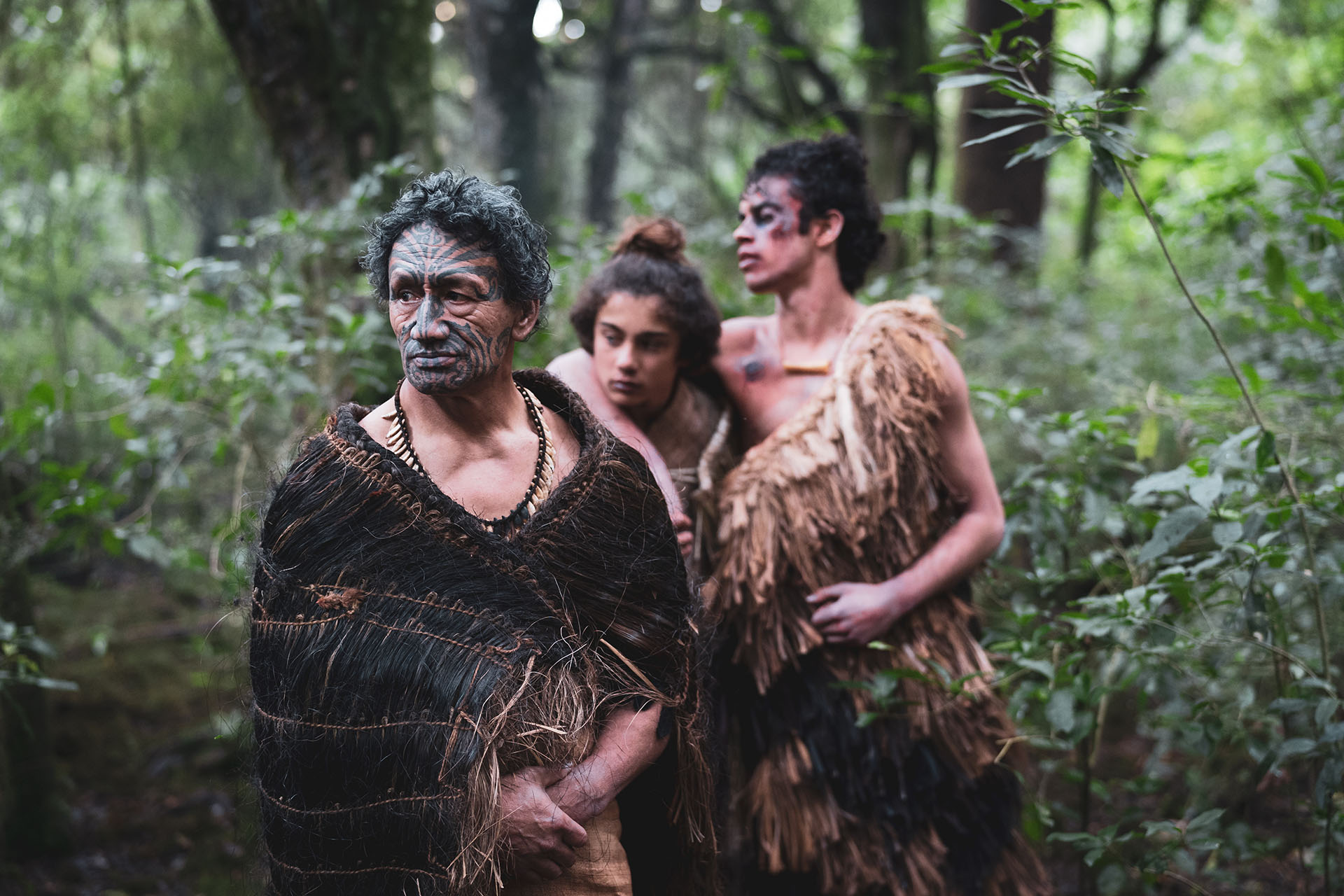 Still from The Untold Tales of Tuteremoana, three Maori male characters walk through the bush